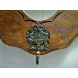 Houten decoratieve kapstok met leeuwenkoppen en spiegel.