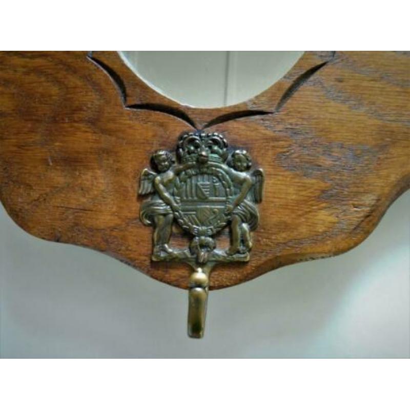 Houten decoratieve kapstok met leeuwenkoppen en spiegel.