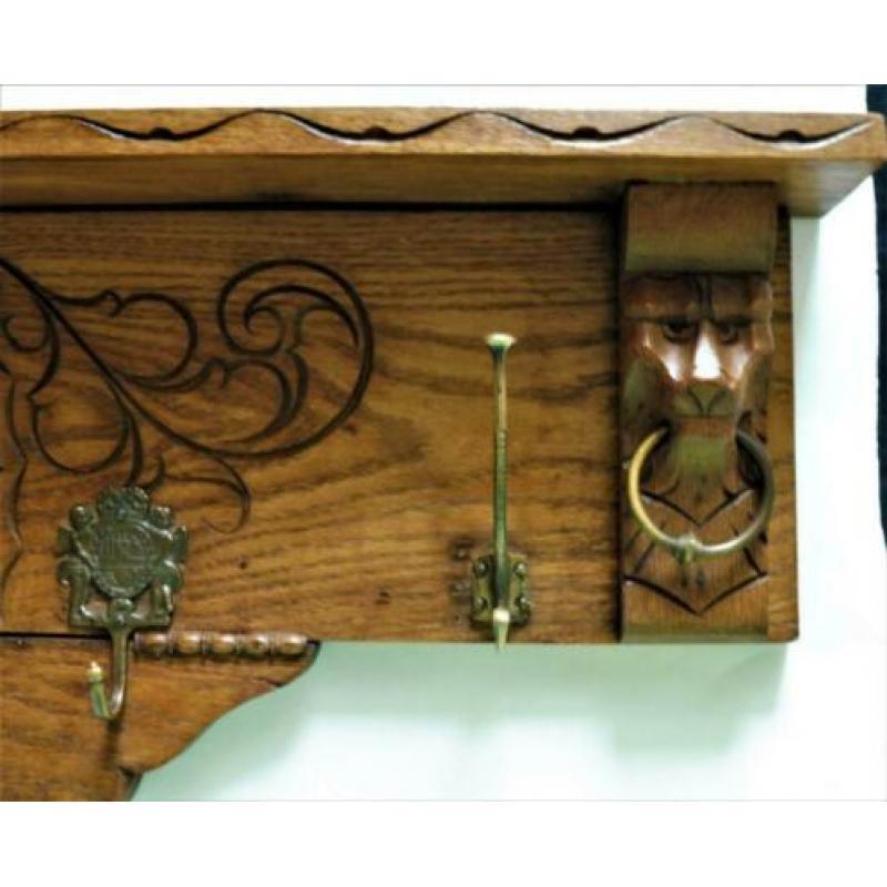 Houten decoratieve kapstok met leeuwenkoppen en spiegel.